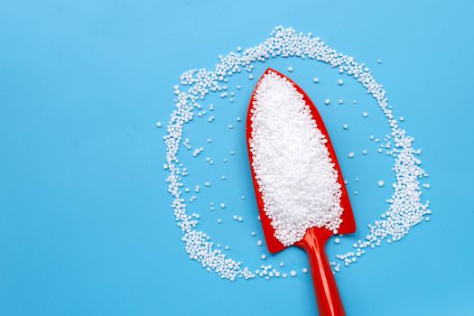 Chemical plant urea fertilizer on blue background. Copy space