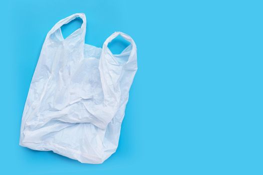 White plastic bag on blue background. Copy space
