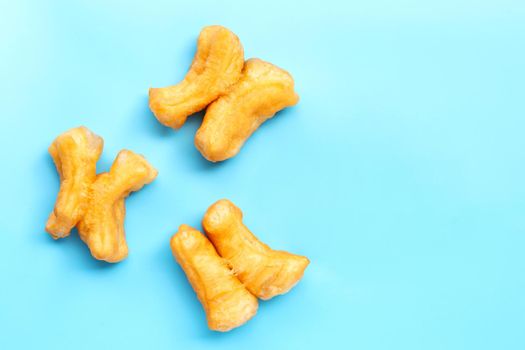 Deep-fried dough stick, chinese bread stick on blue background.  Copy space
