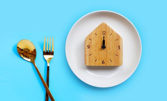 Golden spoon and fork on blue background.  Copy space