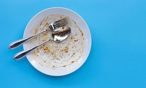 Dirty dish on blue background. Top view