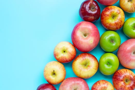 Ripe apples on blue background. Copy space