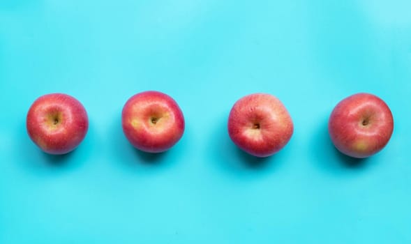 Ripe pink apples on blue background. Copy space