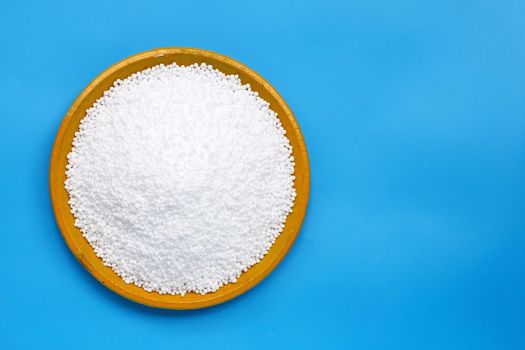 Chemical plant urea fertilizer on blue background. Copy space
