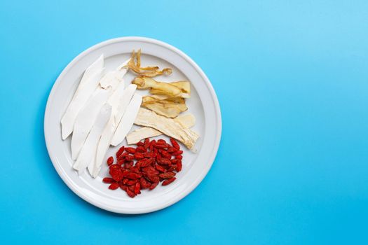 Mixed chinese herb on plate on blue background. Copy space