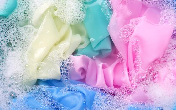 Color clothes soak in powder detergent water dissolution. Laundry concept