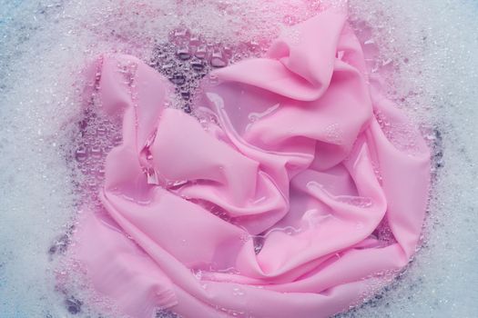 Color clothes soak in powder detergent water dissolution. Laundry concept