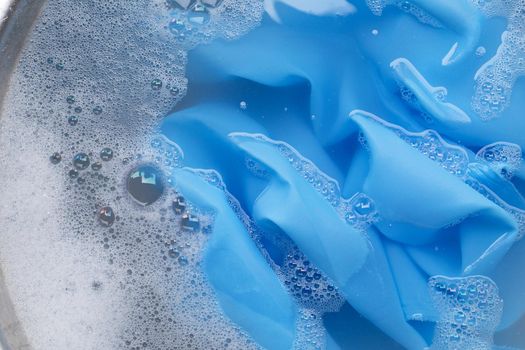 Blue clothes soak in powder detergent water dissolution. Laundry concept