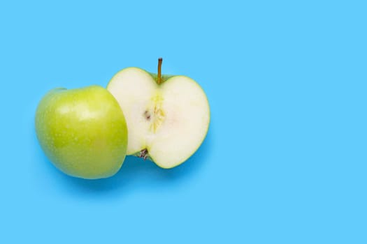 Fresh green apple on blue background. Copy space