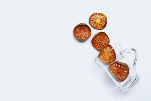Dried bael fruit with glass on white background. Top view