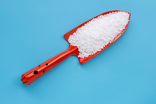 Chemical plant urea fertilizer on blue background. Copy space