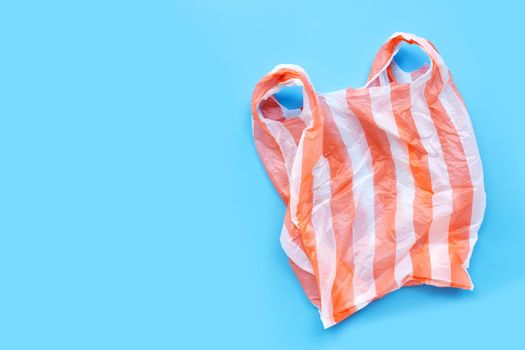 Colorful plastic bags on blue background.  Copy space