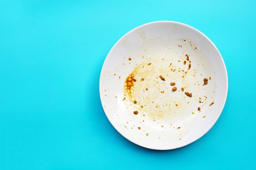 Dirty dish on blue background. Top view, Copy space