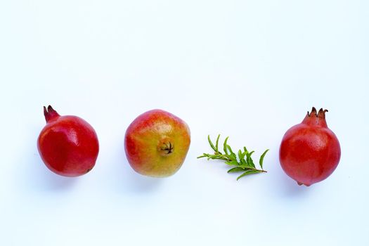 Top view of ripe pomegranate fruit with leaves on white