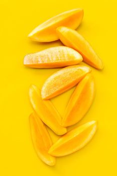 Tropical fruit, Mango  slices on yellow background. Top view