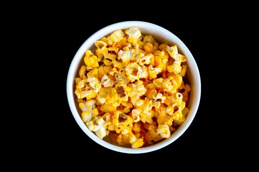 Popcorn in bowl on black background. Top view