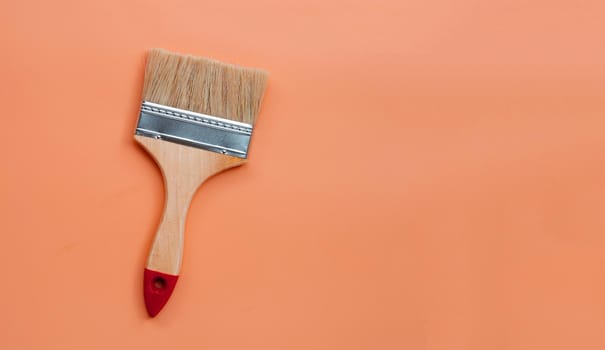 Paint brush on orange background. copy space