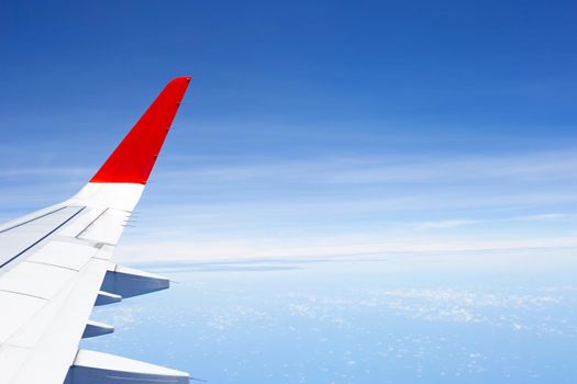 View of sky, cloud and wing of airplane from window