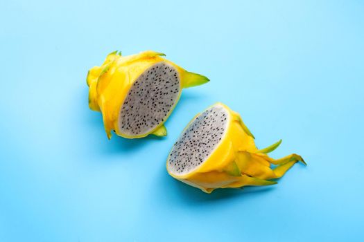 Yellow pitahaya or dragon fruit on white plate on blue background. Copy space