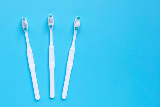 Toothbrushes on blue background. Top view