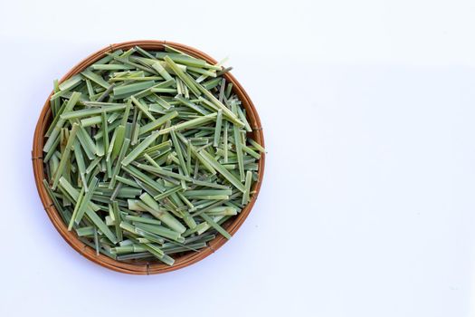 Organic lemongrass cut dry leaves in wooden bowl on white background.