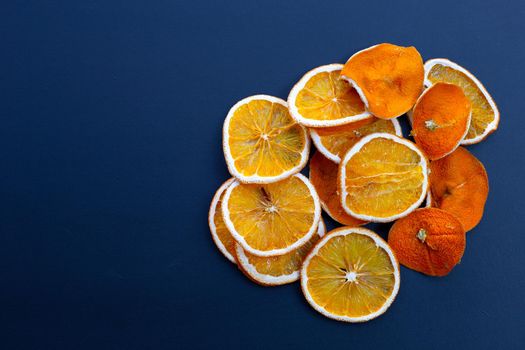 Sliced dry oranges on dark background.