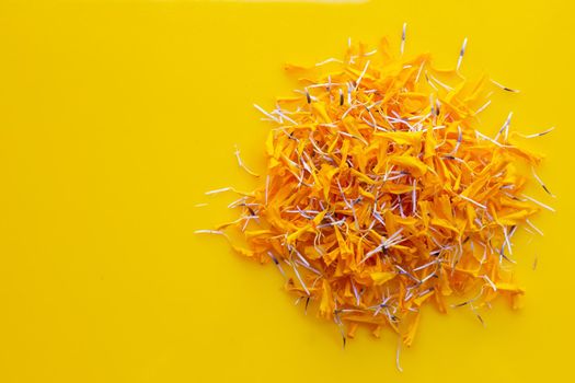 Marigold flower petals on yellow background.