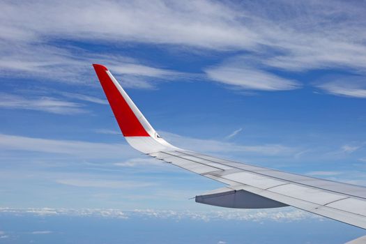 View of sky, cloud and wing from airplane window