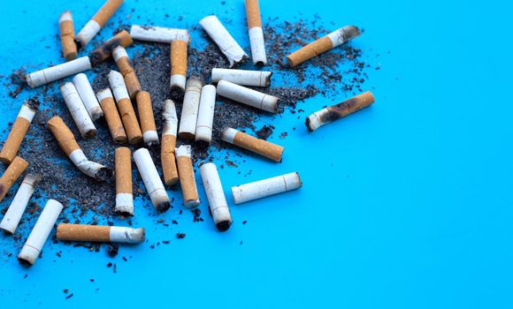 Dirty cigarette buds on blue background.