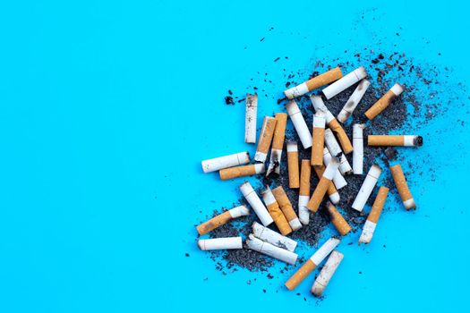 Cigarettes buds with ashtray on blue background. 