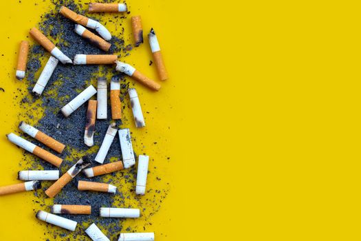 Cigarettes buds with ashtray on yellow background. 