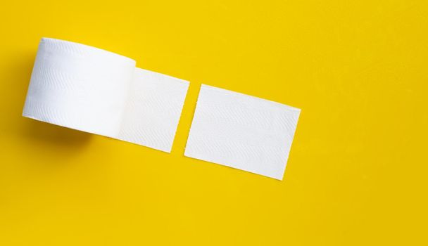 Toilet paper on yellow background. Copy space