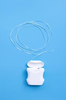 Dental floss on blue background. Copy space