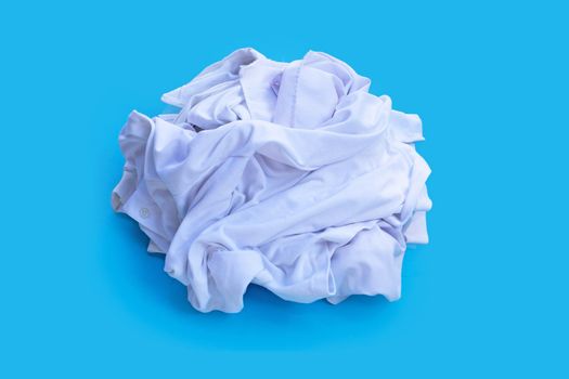 Pile of used clothes on blue background.