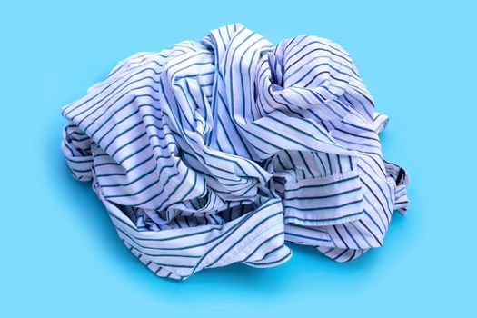 Pile of used clothes on blue background.
