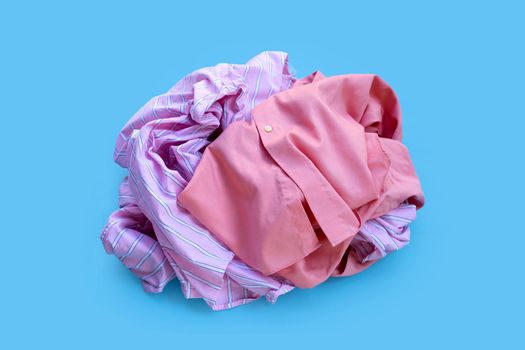 Pile of used clothes on blue background. 