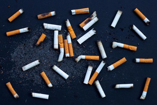 Cigarettes buds with ashtray on dark background.