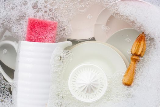 Washing dishes, Close up of utensils soaking in kitchen sink.