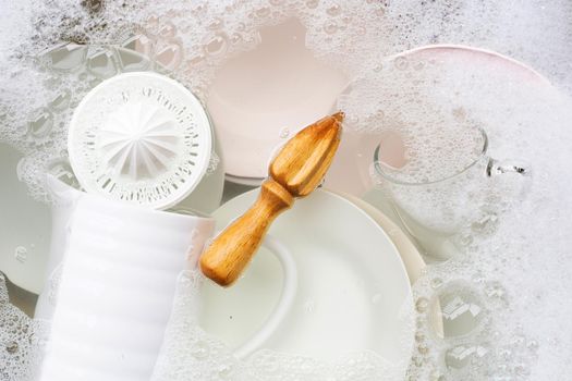 Washing dishes, Close up of utensils soaking in kitchen sink.