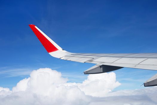 View of sky, cloud and wing from airplane window
