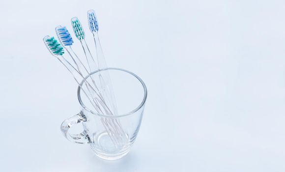 Toothbrushes in a glass on white. Copy space