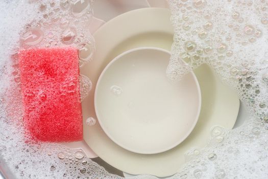 Washing dishes, Close up of utensils soaking in kitchen sink.