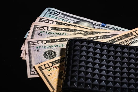 Dollars money banknotes in a black wallet isolated.