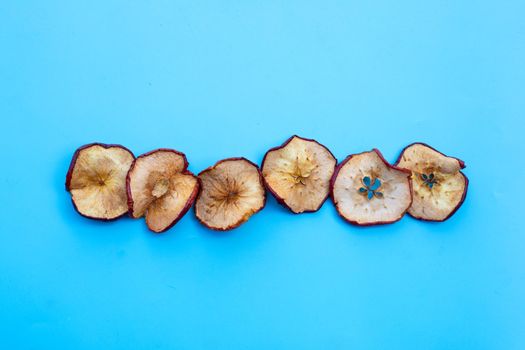 Dried apple slices on blue background.