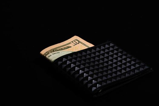 10 Dollars banknotes in a black wallet isolated