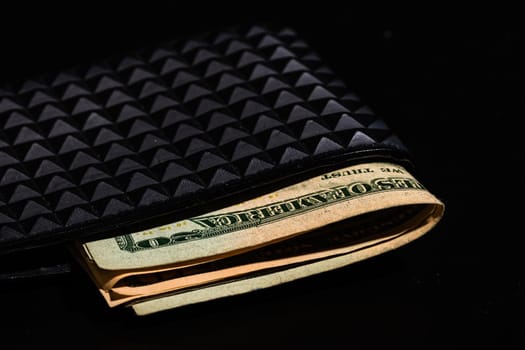 Dollars money banknotes in a black wallet isolated.