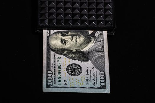 100 Dollars banknotes in a black wallet isolated