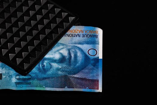 100 swiss franc banknote in a black wallet isolated.