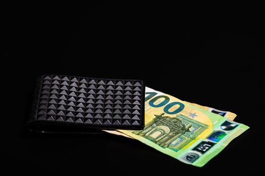 100 Euro money banknotes in black wallet isolated