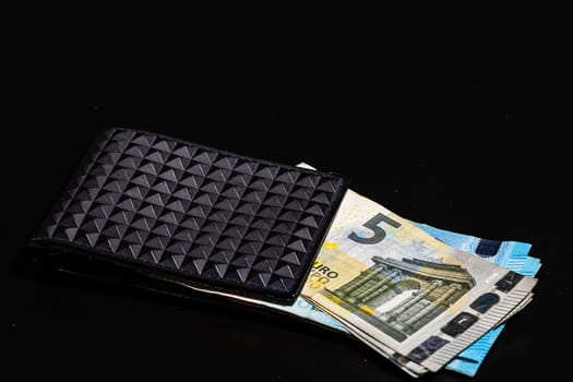 5 Euro money banknotes in black wallet isolated